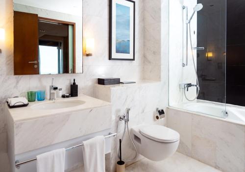 a white bathroom with a toilet and a sink at Fashion Avenue Dubai Mall in Dubai