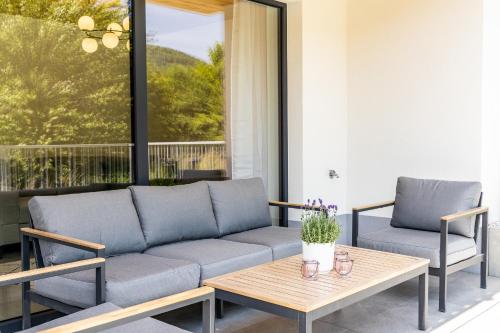 a patio with a couch and a table at Apartamenty Kasztanowa Park Szczyrk in Szczyrk