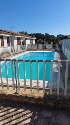 a large swimming pool with a white fence around it at Domu in su satu in Masainas