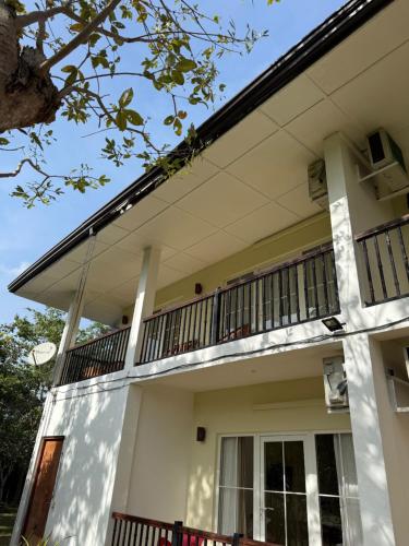 a white house with a balcony at Sungreen Resort Habarana in Habarana