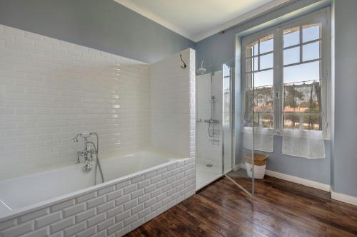 a white bathroom with a tub and a shower at Villa de charme classée à Tharon Plage pour 14 in Tharon-Plage