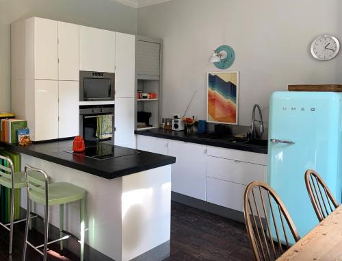 La cuisine est équipée de placards blancs et d'un réfrigérateur bleu. dans l'établissement Berlioz Blue AP4458 by Riviera Holiday Homes, à Nice