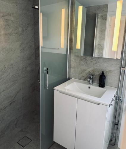 a bathroom with a white sink and a mirror at Litet hus nära Värnamo 