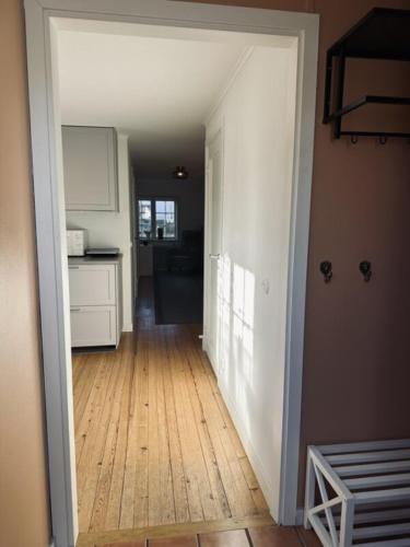 a hallway of a kitchen with a wooden floor at Litet hus nära Värnamo 