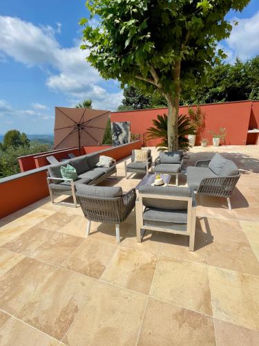 a patio with couches and a table and chairs at Villa Les Chants Vallonnés in Spéracèdes