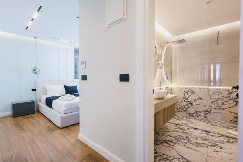 a bedroom with a bed and a bathroom with a sink at Hotel Teuta in Ulcinj