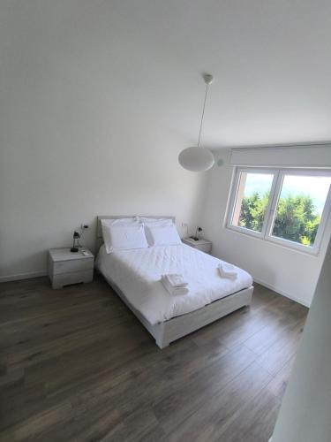 a white bedroom with a bed and a window at BEDE-Bike in Casazza