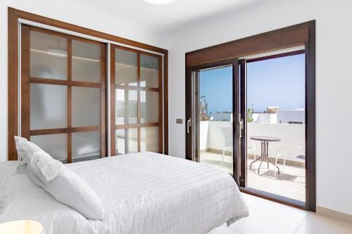 Un dormitorio con una cama y un balcón con una mesa. en Chalet En La Cala De Mijas Costa, en Mijas Costa