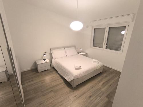 a bedroom with a white bed and a window at BEDE-Bike in Casazza