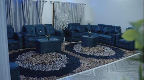 a living room with blue couches and tables at Raaha Luxury Home Stay in Mysore