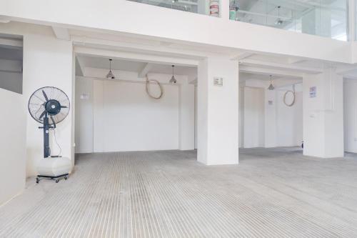 a large room with white walls and a fan at Townhouse Oak Ancol - 6 Hours Stay in Jakarta