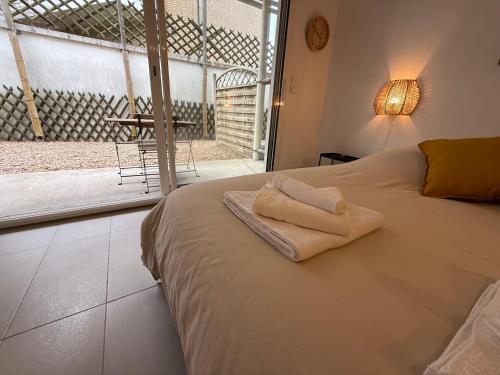 une chambre avec un lit avec deux serviettes dessus dans l'établissement Luxury Zen & Love Studio - Proche Paris & Disneyland, à Neuilly-sur-Marne