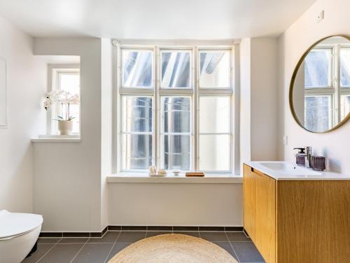 a bathroom with a sink and a toilet and a mirror at Sanders Regent Bright apartment in city center in Copenhagen