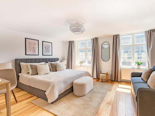 a bedroom with a large bed and a couch at Sanders Regent Bright apartment in city center in Copenhagen