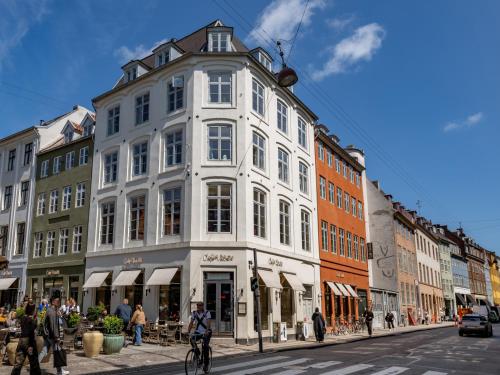 a white building on a city street with people walking at Sanders Regent Bright apartment in city center in Copenhagen