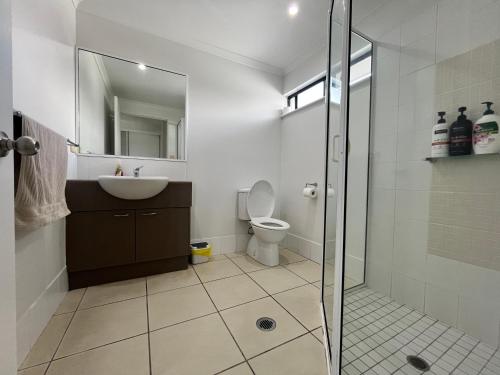 a bathroom with a toilet and a sink and a shower at Cairns Central Atrium Apartments & Studio in Cairns