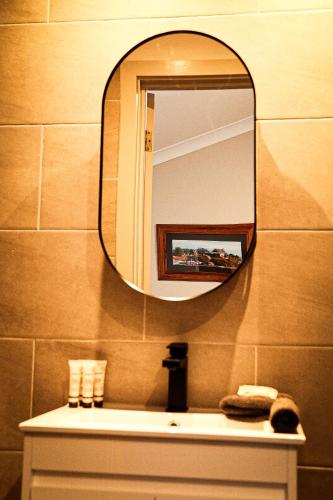 a bathroom with a mirror over a sink at Cooroona Alpine Lodge in Falls Creek