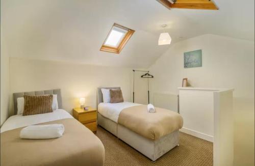 una camera da letto con due letti e una finestra di The Red Retreat, 7 Beds, Garden, Free Parking, Contractors, Fast Wifi, Smart TV a Liverpool