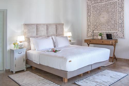 a bedroom with a large white bed and a table at Georgia Villas in Skiathos