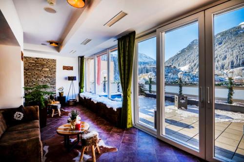 a living room with a bed and a large window at Luxus-Lodge Kaiser Franz Josef im SCHILLER in Bad Gastein