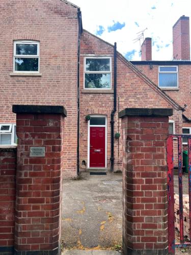 a red brick house with a red door at On The Avenue Apt 3 in Nottingham