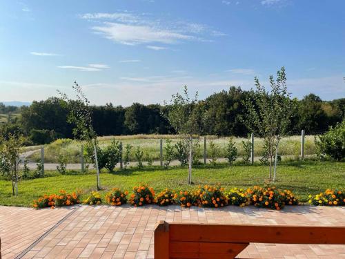 a park with a bench and flowers in a field at Brvnara N&N in Laktaši