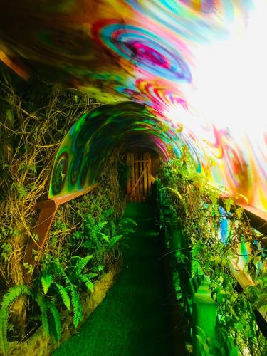 a tunnel with plants in it with a colorful painting at Serendipity Lake Artistic Bungalow by Heidis Home in Nuwara Eliya