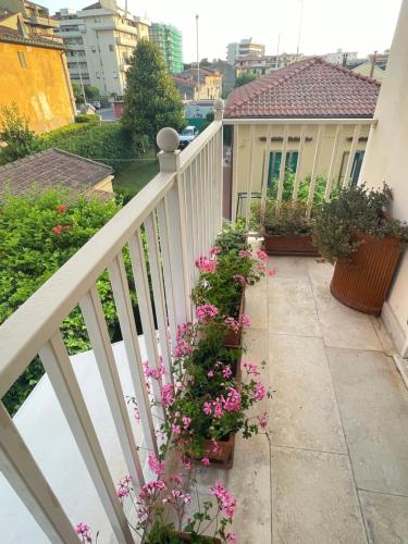 a balcony with flowers and a white fence at Ars in Villa in Livorno