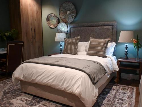 a bedroom with a large bed with a blue wall at Waterwoods Equestrian Venue and Cottages in Nottingham Road