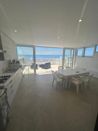 a kitchen with a table and a view of the ocean at GAETA VILLA Sul MARE in Sperlonga