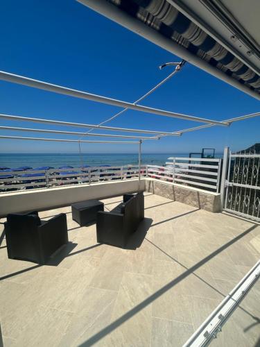 a view of the beach from a balcony with benches at GAETA VILLA Sul MARE in Sperlonga