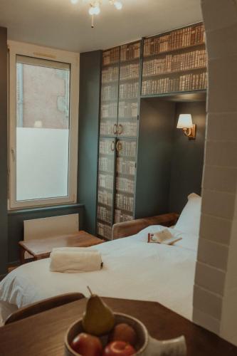 une chambre d'hôtel avec un lit et un bol de fruits sur une table dans l'établissement Victor Hugo, à Besançon