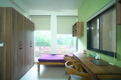 ein Esszimmer mit einem Tisch und einem Fenster in der Unterkunft Grihum Living Girls - FEMALE ONLY in Ranchi