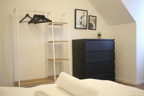a bedroom with a bed and a shelf and a dresser at Apartment für 7 I 2 Min bis Hbf I Smart TV I WiFi I modern in Hamm