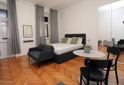 a bedroom with a bed and a chair and a table at Nona Marija Centar Apartments in Pula