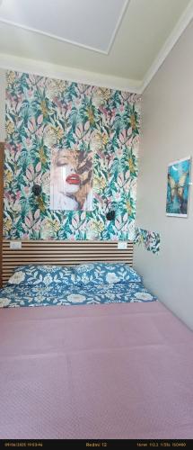 a bedroom with a bed with a painting on the wall at EnjoyCasa Tra Sole Mare e L'Etna in Adrano