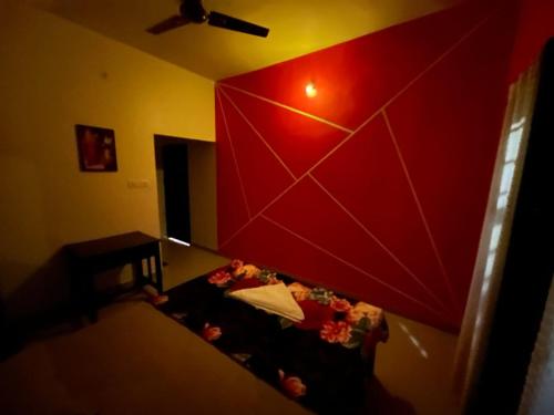 a living room with a red wall and a couch at Phoenix Odayam in Kappil