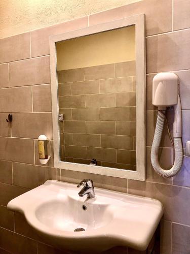 a bathroom sink with a mirror and a phone at Hotel Santo Stefano in Portoferraio