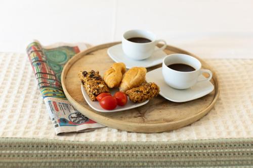 a tray with two cups of coffee and food at Renovated apartment near Acropolis in Athens