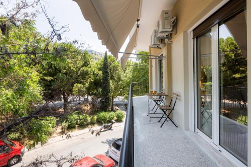 a balcony with a table and dogs walking on a street at Renovated apartment near Acropolis in Athens