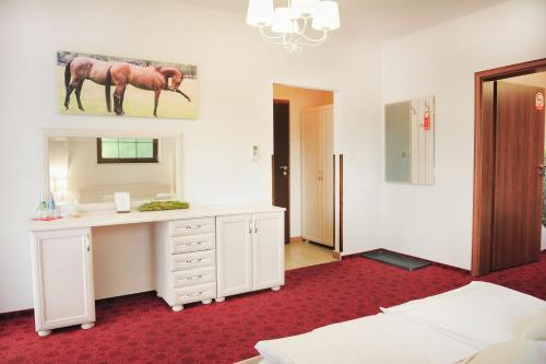 a bedroom with a desk and a bed and a mirror at Malutkie Resort in Radomsko