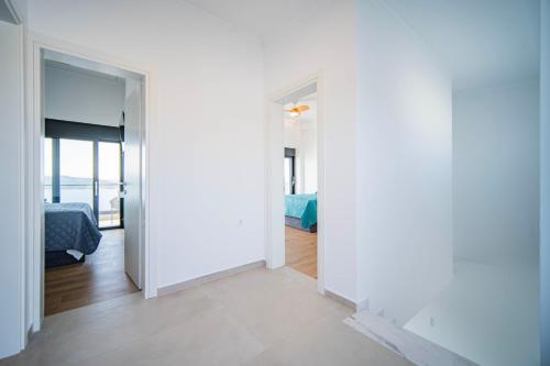 a room with white walls and a bedroom with a bed at Alexandria Seaside Luxury Villas in Kriaritsi in Sikia