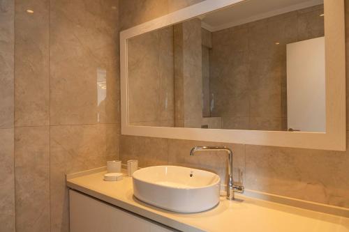 a bathroom with a sink and a mirror at Alexandria Seaside Luxury Villas in Kriaritsi in Sikia