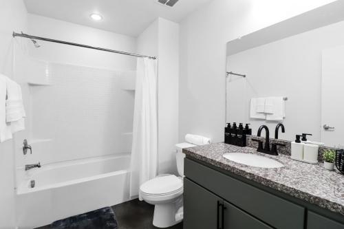 a white bathroom with a toilet and a sink at Centric 2BR In HEART of DTPHX Free Garage Parking in Phoenix