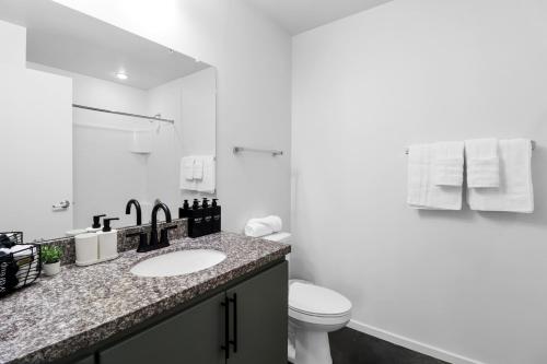 a white bathroom with a sink and a toilet at Centric 2BR In HEART of DTPHX Free Garage Parking in Phoenix