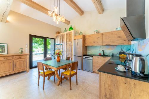 a kitchen with a table and a dining room at Tilleul enchanté in Malaucène