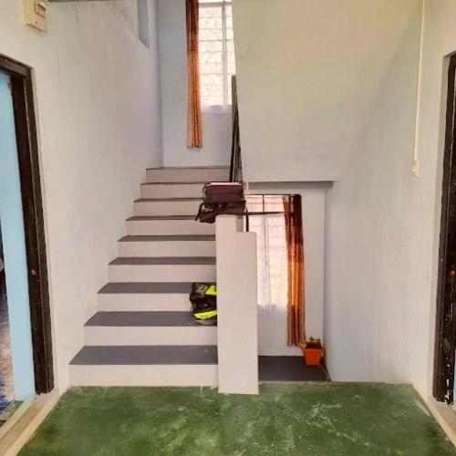 a room with stairs with a person laying on the floor at Zinnia Homestay in Cherrapunji