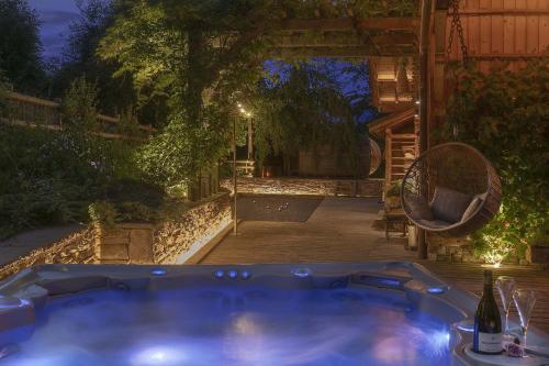 - un bain à remous dans l'arrière-cour la nuit dans l'établissement CHALET LES CERISES Jacuzzi, Sauna, Hammam, Cinéma, à Cordon