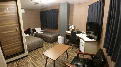 a hotel room with a bed and a television at Hotel Port Moji in Kitakyushu