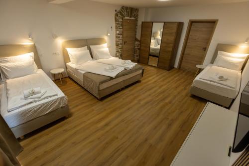 a hotel room with two beds and a mirror at Bed & Breakfast Adelsberg Inn in Postojna